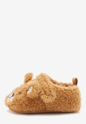 Zapatilla marrón suave y peluda diseñada como un oso con orejas, ojos, nariz y boca bordados, y una lengüeta para tirar en el talón.