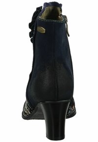 Stivale alla caviglia in suede blu navy con tacco nero testurizzato, dettagli arricciati, zip argentata e lati decorati. Dettaglio logo metallico sul retro.
