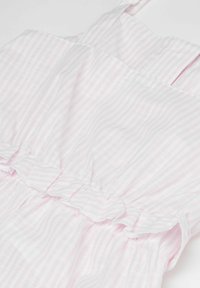 Hellrosa gestreiftes Kleid aus Stoff mit Rüschendetails, dünnen Trägern und gerafftem Bund. Strukturiertes Baumwollmaterial ist sichtbar.
