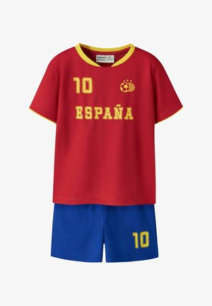 Rood voetbalshirt met korte mouwen en gele afwerking, "10" en "ESPAÑA" in geel, gecombineerd met blauwe shorts met een gele "10" op het been.