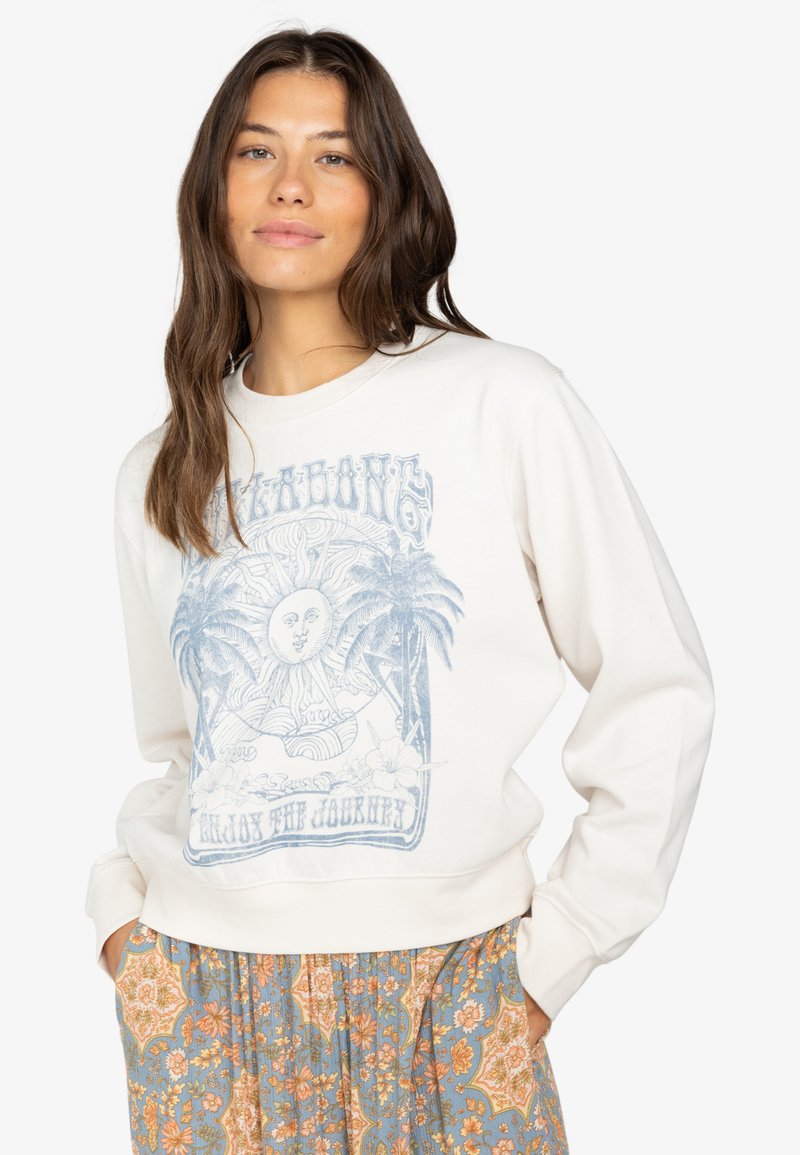 Crème sweatshirt met lichtblauwe graphic met een zon en palmbomen. Zachte stof, ronde hals, relaxte pasvorm, gecombineerd met gestreepte broek.
