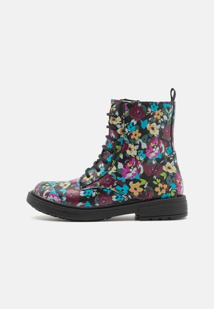 Bottes de cheville à imprimé floral avec une base noire, ornées de fleurs multicolores, possédant un avant lacé et une semelle en caoutchouc noir robuste.