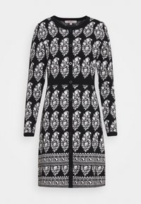 Robe cardigan noire ornée d'un motif de feuilles blanches, manches longues, fermeture boutonnée à l'avant, et taille côtelée avec un détail décoratif à l'ourlet.