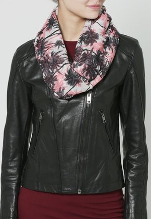 Femme portant une veste en cuir noire et une écharpe rose avec un motif de palmiers noirs, sur un haut bordeaux.