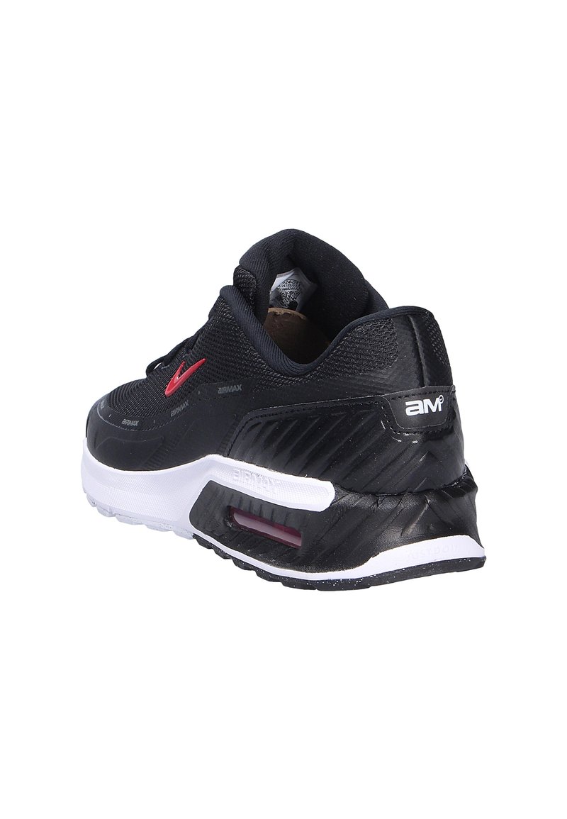 Zapatilla deportiva negra con un upper texturizado, acentos rojos, una suela blanca y un elemento de amortiguación de aire visible en el talón.