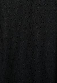 Tecido de renda preta apresentando um padrão texturizado de diamantes e laços entrelaçados. Macio, semi-transparente e com um acabamento delicado.