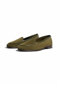 Maslinasto zelene loafers cipele od mekanog antilopa, s okruglim vrhom i kontrastnim tamnozelenim obrubom. Lagana drvena potpetica s minimalnim detaljima.
