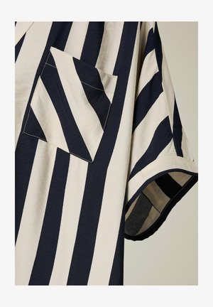 Camisa de manga corta a rayas en azul marino y crema con un bolsillo en el pecho y un corte relajado. Fabricada con un tejido texturizado y un acabado suave.