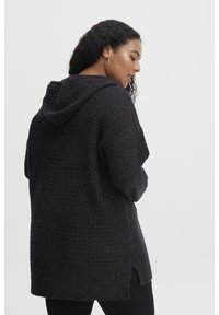 Hoodie en tricot violet foncé avec une coupe oversize, motif texturé, fentes sur les côtés et capuche. Tissu doux avec une silhouette décontractée.
