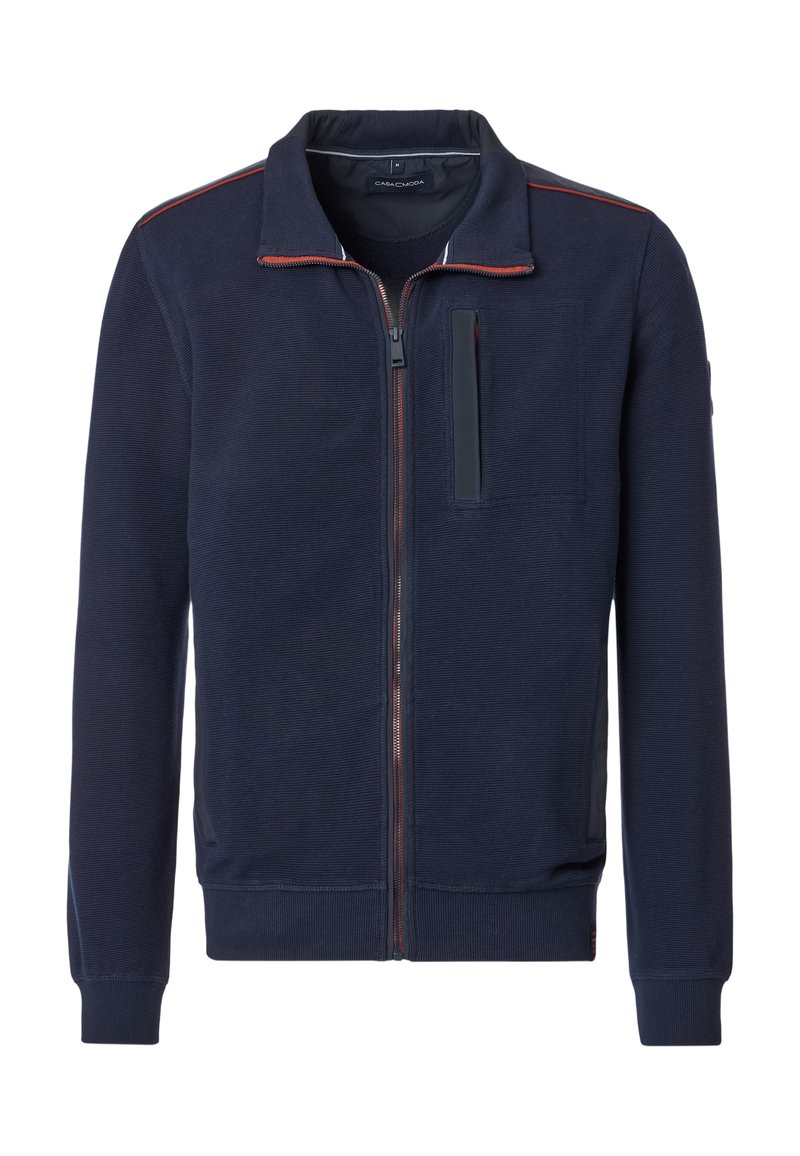 Marineblaue Zip-Jacke mit strukturierter Oberfläche, kontrastierenden roten Nähten, einer Tasche mit Klappe sowie gerippten Bündchen und Saum. Lässiges Design.