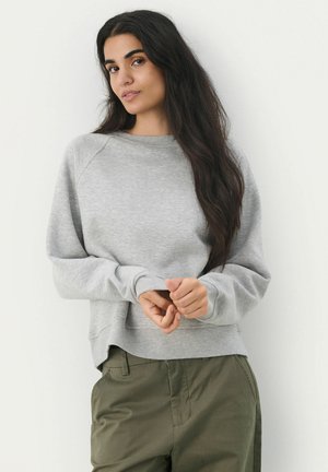 Grijze sweatshirt met een relaxed fit, ribbels aan de manchetten en tailleband. Zachte textuur, lange mouwen en raglanontwerp. Draagt met olijfgroene broek.