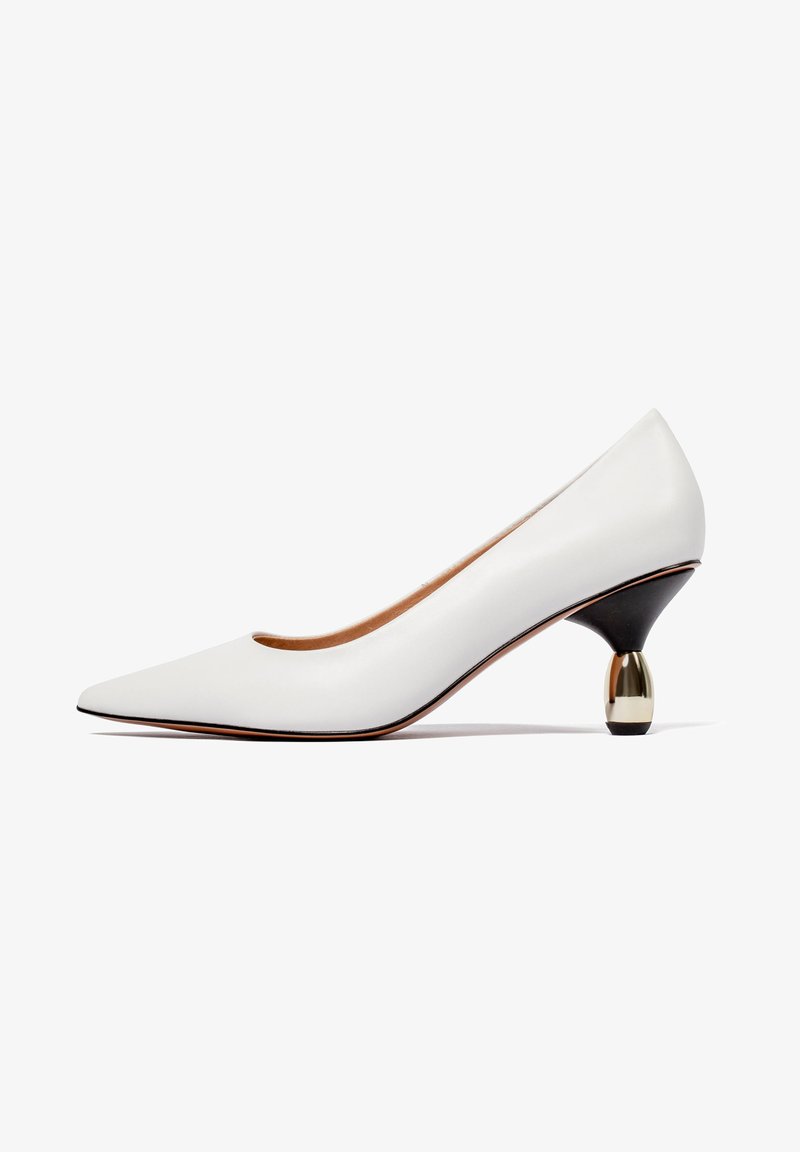 Chaussure à talon haut à bout pointu blanche avec un talon aiguille incurvé unique noir et doré sur fond blanc.