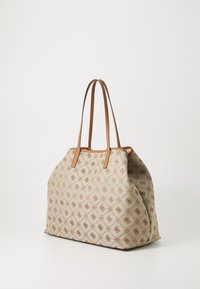Sac en toile beige avec des anses en cuir marron, présentant un motif subtil de symboles, une texture lisse et une forme douce et spacieuse.