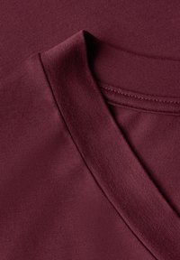 Marin V-ringad t-shirt med mjuk textur och sömdetaljer vid halsringningen. Tyget är mjukt och något stretcht.