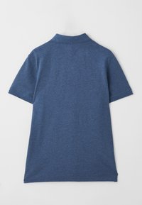 Sinine lühikeste varrukatega polo särk kraega, nähtud tagant valgel taustal.