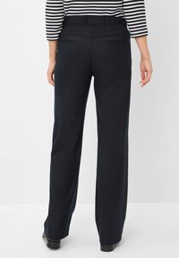 Wijde broek in marineblauwe stof, met een elastieken tailleband en twee achterzakken, ontworpen voor comfort en gemak.