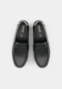 Schwarze Leder-Slipper mit glatter Textur, ausgestattet mit einem Vorderriemen und einer Stichdetails, Logo an der Innensohle und einer abgerundeten Zehenpartie.