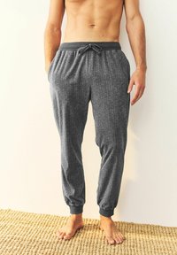 Graue Herringbone-Jogginghosen mit elastischen Bündchen und Kordelzugbund, aus weichem Material, mit Seitentaschen und lockerer Passform.