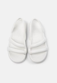 White molded sandals with three wide straps, textured footbed, and a smooth surface. Lightweight design suitable for casual wear.