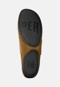 Suela de un zapato marrón que muestra un agarre de goma negra con la palabra "PER" y el tamaño "38" grabados en ella. El diseño texturizado proporciona tracción.