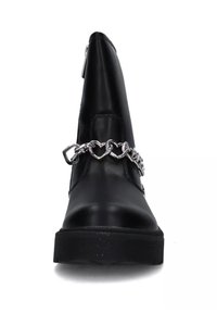 Stivale alla caviglia nero con punta affusolata, finitura in pelle opaca e un accento di catena argentata con link a forma di cuore che attraversano la parte anteriore.