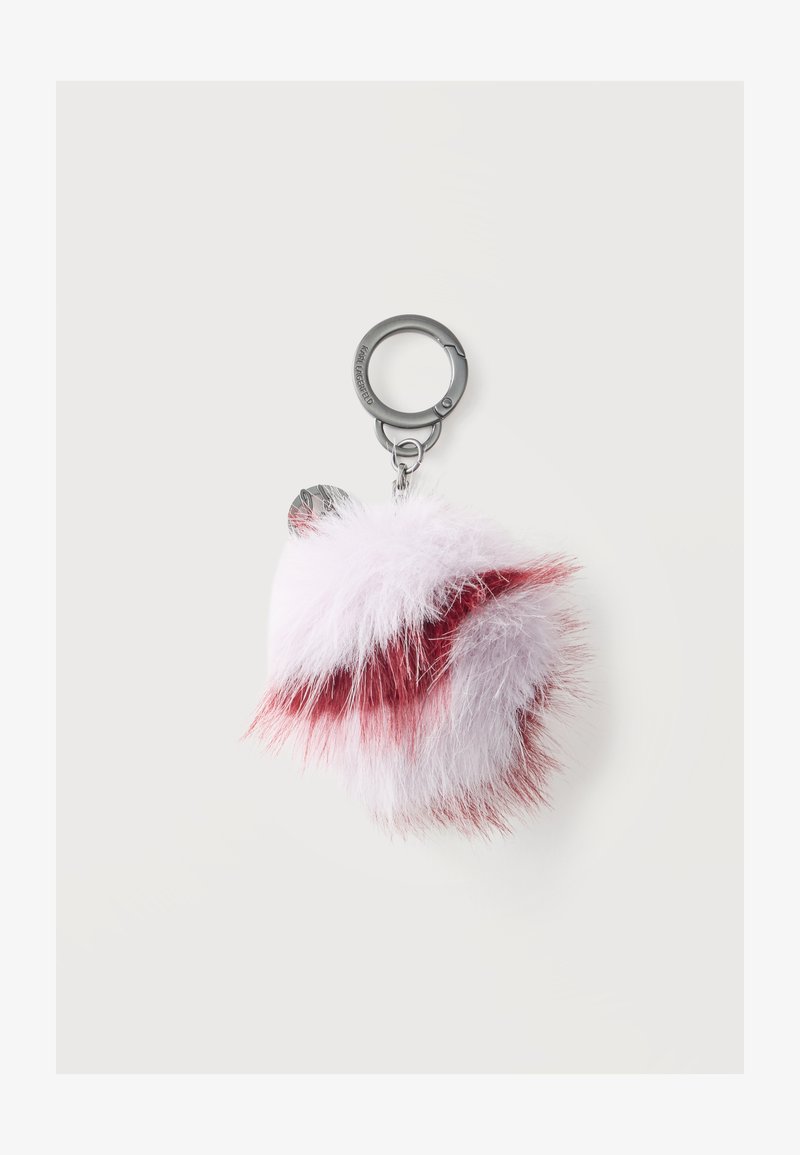 Porte-clés duveteux avec fourrure blanche et rouge attaché à un anneau métallique argenté et un fermoir sur un fond clair uni.