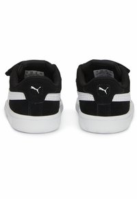Zapatillas negras con parte superior de ante y malla, franjas blancas contrastantes, puntera redondeada y suela de goma blanca texturizada. Logo de PUMA en el talón.