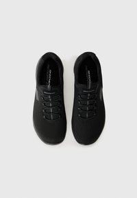 Baskets de sport noires avec une tige en mesh respirant, des lacets élastiques, une semelle en caoutchouc noire et des semelles "Memory Foam" pour le confort et le soutien.