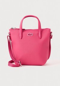 Borsa sintetica rosa con due manici, tracolla removibile, chiusura a zip e logo Lacoste. Design compatto con finitura testurizzata.