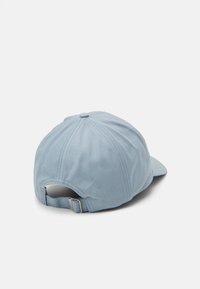 Lys blå bomullcaps med buet skjerm, sekspaneldesign og justerbar stropp bak. Glatt tekstur og enkle sømmer.
