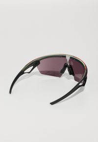 Sonnenbrille mit umschließendem Design, schwarzem Kunststoffrahmen, dunkellila Gläsern und grünen sowie roten Akzenten entlang der oberen Kante. Leichte Konstruktion.