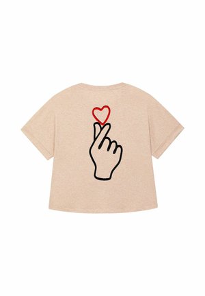T-shirt beige a maniche corte con una grafica che rappresenta una mano che forma un gesto a cuore, con un cuore rosso sopra di essa.