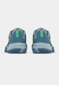 Μπλε αθλητικά παπούτσια με υφασμένο πάνω μέρος, πράσινες λεπτομέρειες και ανθεκτική σόλα. Διαθέτουν διακριτικό λογότυπο στο πίσω μέρος.