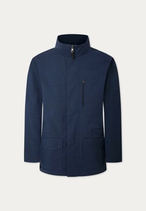 Giacca blu navy con collo alto, chiusura frontale a zip, due tasche laterali e una tasca sul petto con zip. Realizzata in tessuto testurizzato.