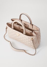Borsa a tracolla beige trapuntata con doppio manico e tracolla in catena, con dettagli in oro e un logo triangolare.