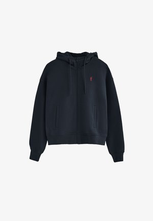 Sudadera con cremallera de color azul oscuro, hecha de una tela suave, con capucha ajustable, dos bolsillos laterales y un pequeño logo rojo en el pecho.