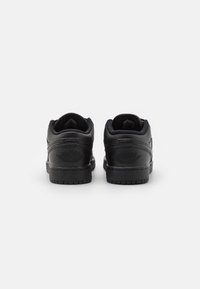 Schwarze Leder-Sneaker mit einem Low-Top-Design, das mit strukturierten Akzenten, abgerundeten Kanten und einer gemusterten Außensohle ausgestattet ist. Prägedruck-Logo an der Ferse.