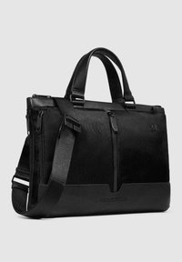 Bolsa estructurada para portátil negra con detalles de cuero, tela texturizada, asas superiores, correa de hombro desmontable y bolsillo delantero con cremallera.