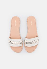 Bílé skluzné sandály s širokým popruhem a výřezovým designem. Jemně růžová stélka se švy. Plochá podrážka, otevřená špička.