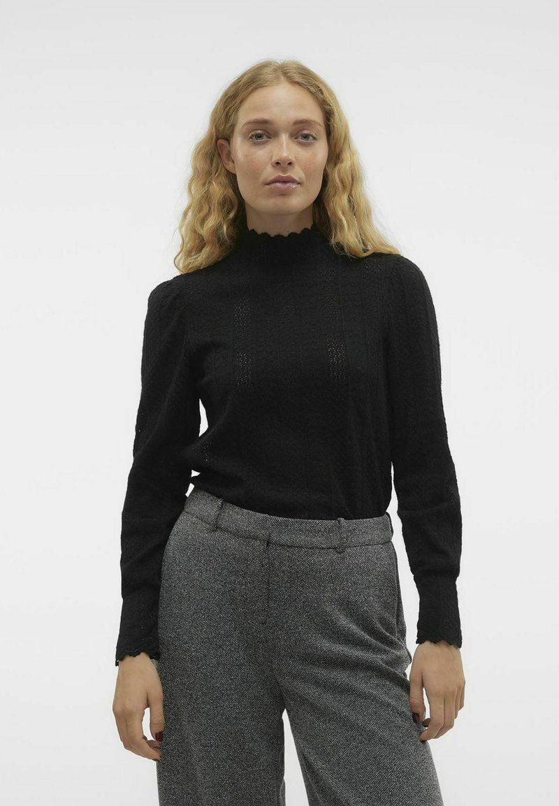 Zwarte textuur lange mouwen top met een hoge scalloped halslijn, gecombineerd met grijze op maat gemaakte broek met een subtiel patroon en een rechte snit.