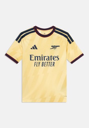 Maillot de football jaune de l'Arsenal avec des bandes noires Adidas, logo Emirates Fly Better, et bordure rouge et noire au col et aux manches.