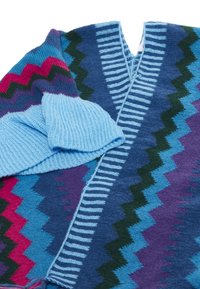 Stickad tröja med livliga zick-zack-mönster i blått, lila, rosa och grönt. V-ringad design med ribbade blå ärmar.