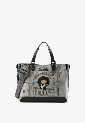Sac à main gris et noir avec motif femme et chien de dessin animé, poignées noires et bandoulière grise ajustable avec accents de texte.