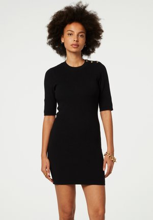 Schwarzes geripptes Strickkleid mit kurzen Ärmeln, Rundhalsausschnitt und dekorativen goldenen Knöpfen an den Schultern. Figurisierte Silhouette und glatte Textur.