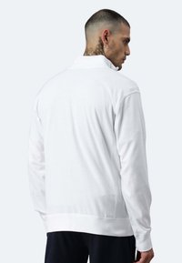 Weißer Pullover mit langen Ärmeln und hohem Kragen, glatter Textur und gerippten Bündchen. Figurnahe Passform mit einem schlichten Rückendesign.