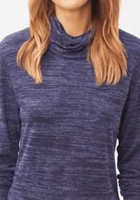 Jersey azul marino con cuello vuelto hecho de tejido de punto texturizado. Cuenta con un pequeño bolsillo frontal y un ajuste holgado.