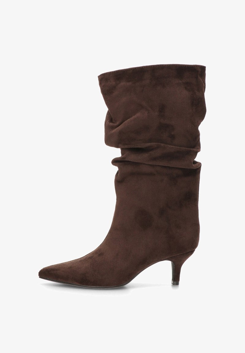 Botín de ante marrón con diseño holgado, punta puntiaguda y tacón bajo tipo kitten. El material tiene un acabado suave y texturizado.