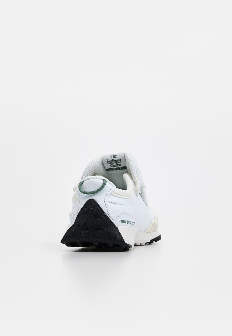 Sneaker blanc avec des superpositions texturées, des accents verts et noirs, un col rembourré, et une semelle en caoutchouc avec un motif clouté.