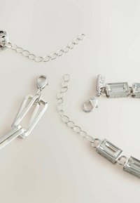 Composants de bijoux en argent comprenant des maillons de chaîne, un gros fermoir et des accents en cristal rectangulaire, avec une finition polie et des formes variées.