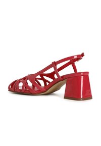 Sandalo slingback in pelle verniciata rossa con design a ritaglio geometrico, tacco quadrato e cinturino alla caviglia regolabile per una vestibilità sicura.